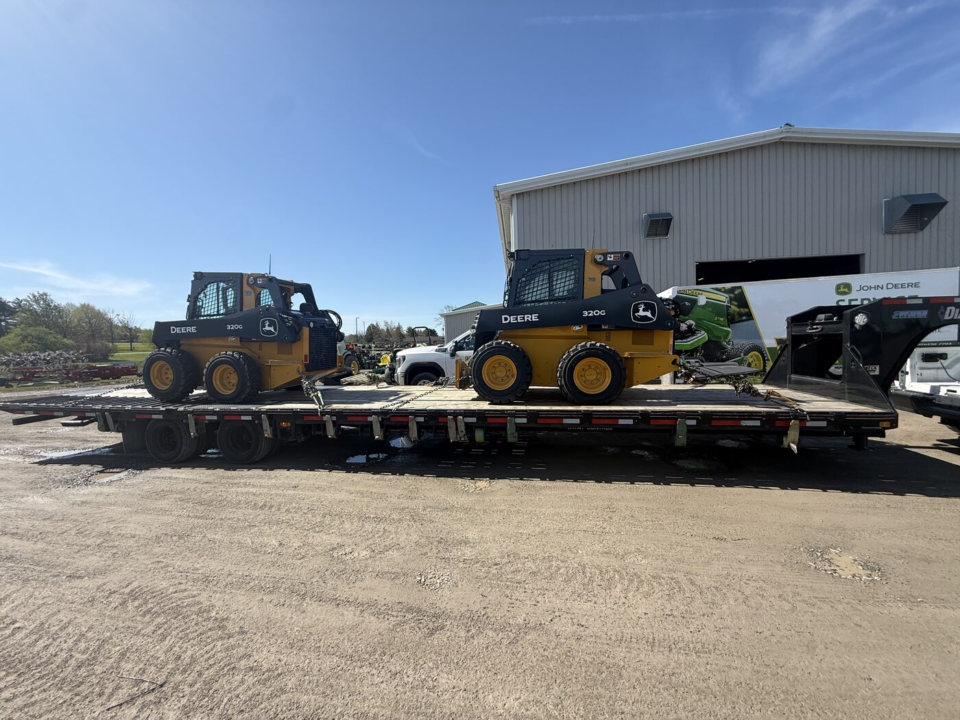 Two John Deere skid steers loaded on an AG Motion hotshot trailer