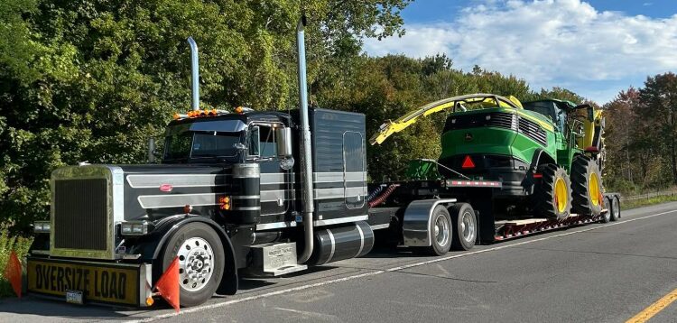 AG Motion hauling a John Deere silage chopper