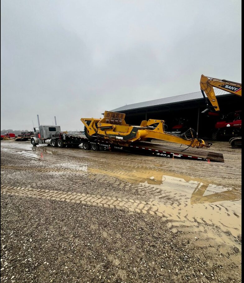 AG Motion hauling a dirt pan on a Landoll trailer