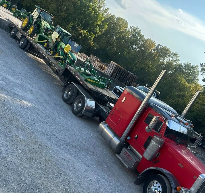 AG Motion step deck loaded with John Deere tractors and a batwing mower